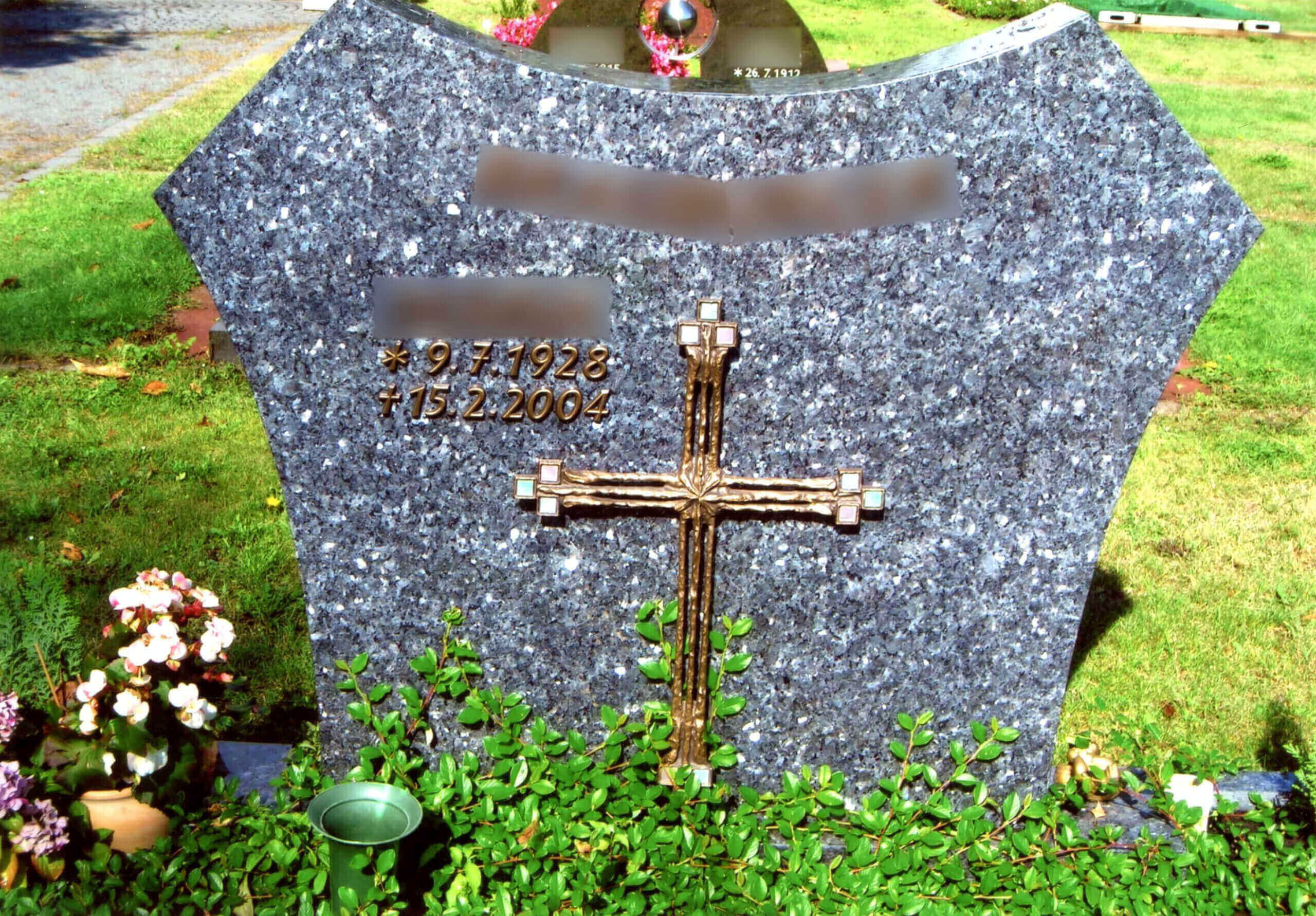 Goldenes Kreuz und Inschrift auf Stein