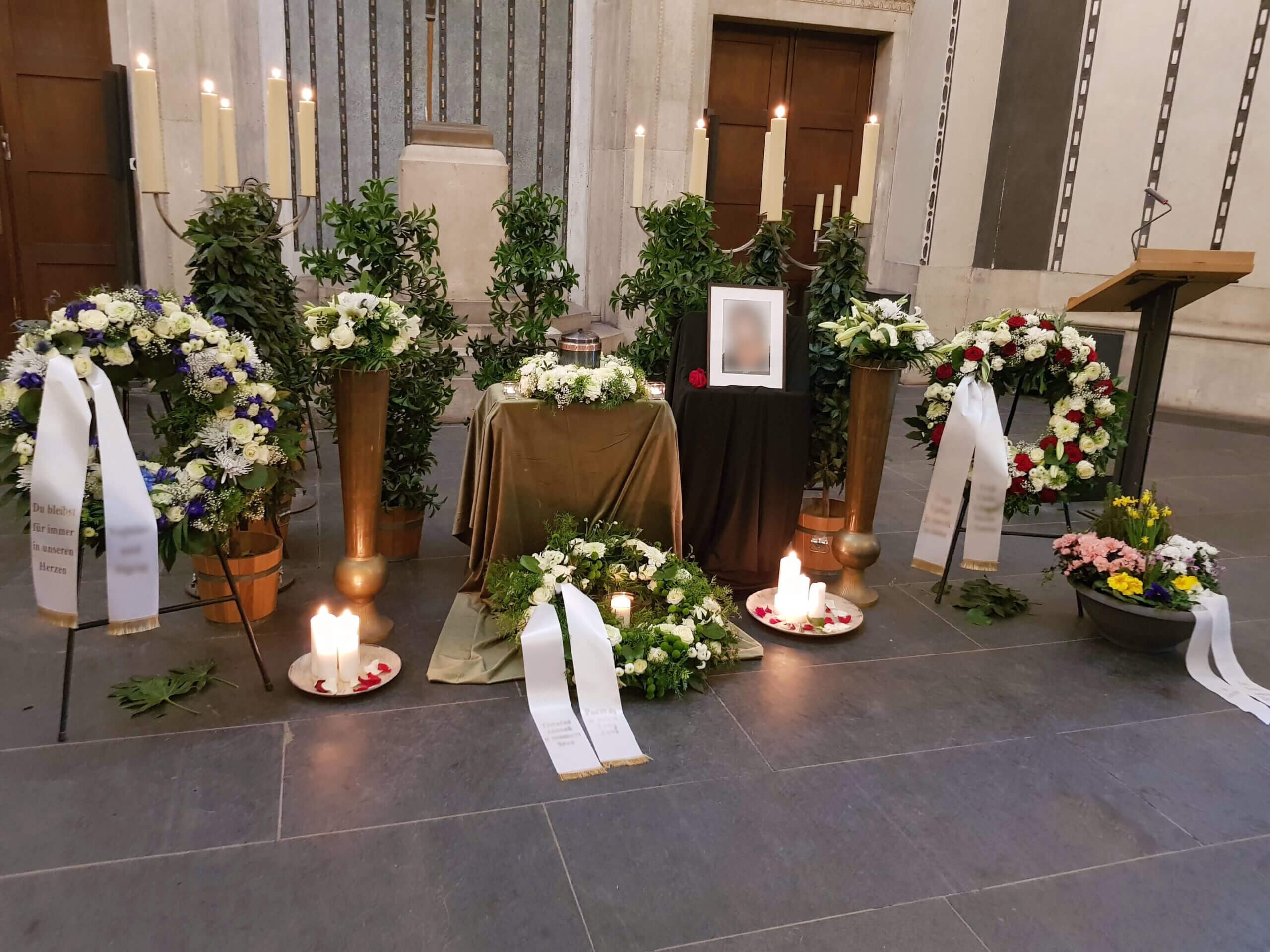 Beleuchteter Altar in Trauerhalle mit Bild